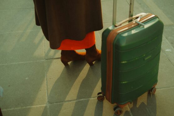 Traveler standing with a suitcase on a sunlit pavement, symbolizing the journey tourists take—and how an optimized Tripadvisor profile can guide them straight to your business.