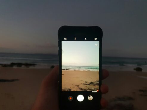 Capturing a beach scene with a smartphone in vertical format—perfect for creating eye-catching travel content that connects with audiences on social media.