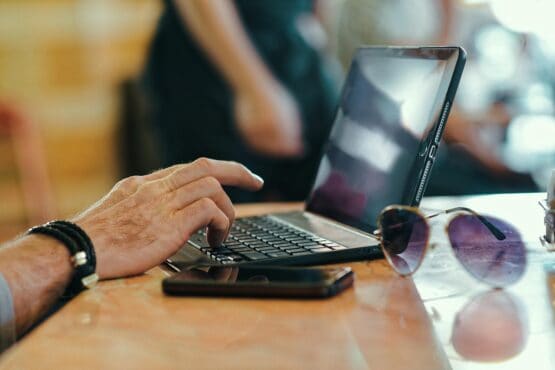 Person working on a tablet with a keyboard at a café, symbolizing online reputation management and handling customer reviews for small businesses.