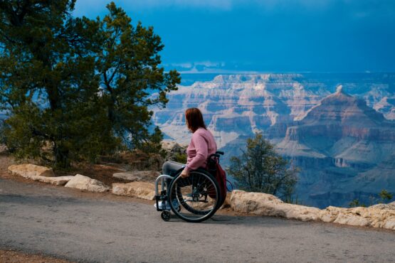 Woman in wheelchair enjoying accessible viewpoint at Grand Canyon. Thumbnail for video teaching businesses how to support travelers with disabilities by adding accessibility details to their online listings on Google and other platforms.