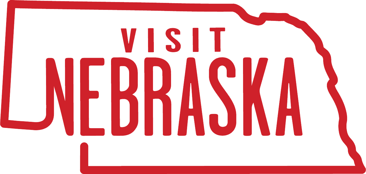 Red outline of Nebraska state with the words “Visit Nebraska” in bold red letters inside the state shape.
