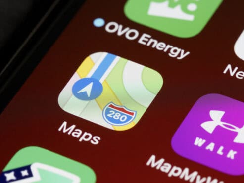 Close-up of a smartphone screen showing the Apple Maps app icon, with OVO Energy and MapMyWalk icons nearby.